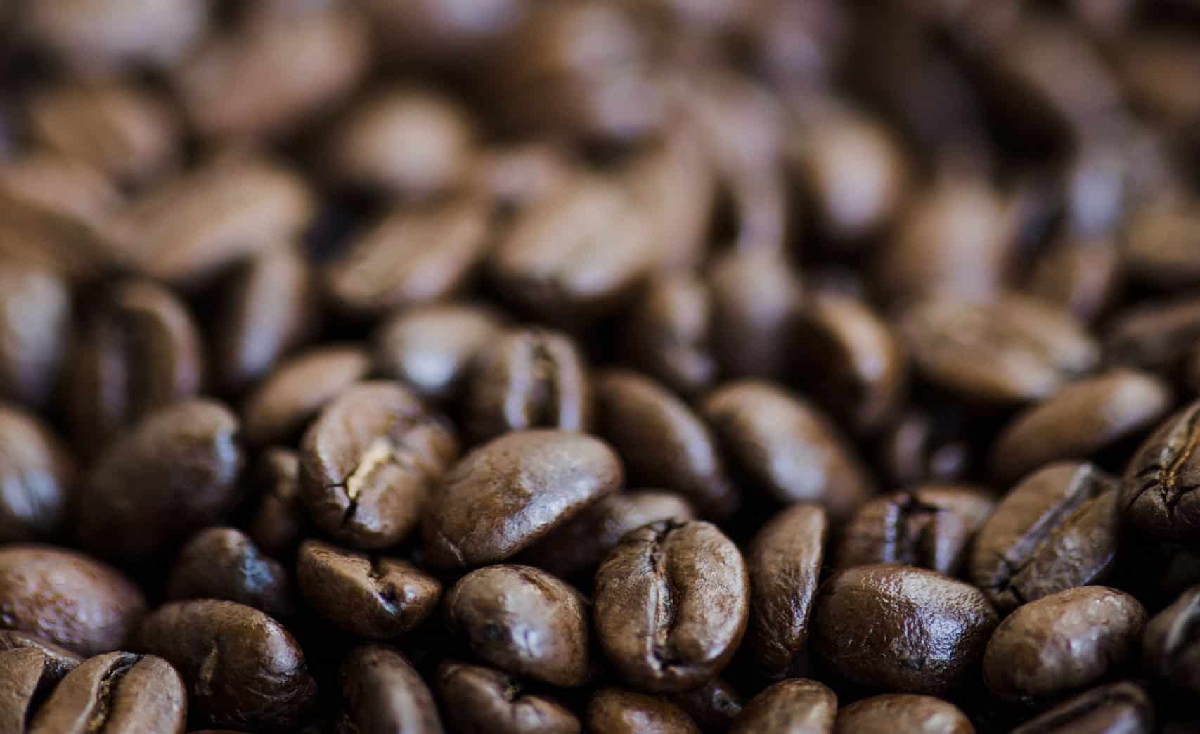 Close-up of roasted coffee beans with shiny, textured surfaces.